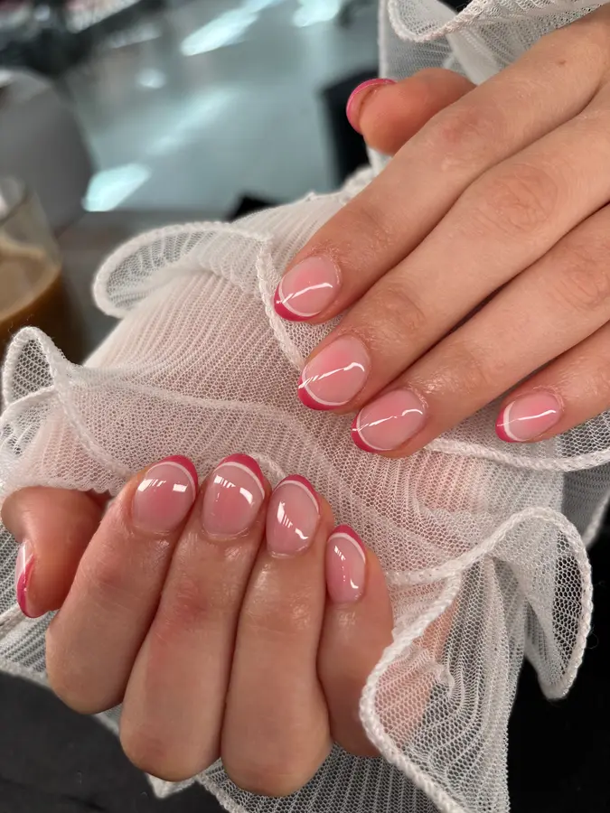 Kurze, runde Nägel mit rosa Doppellinien-French auf weißem Tüll